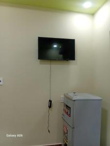 a flat screen tv on the wall above a refrigerator at HOTEL MOTeL ĐỒNG KHỞI in Ben Tre +95 photos