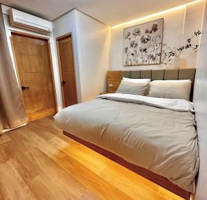a bedroom with a large bed and a wooden floor at Annie's Place Puerto Princesa in Puerto Princesa City