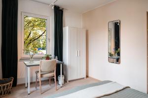 a bedroom with a desk and a table with a window at Stivolles Ambiente in Niendorf! in Hamburg