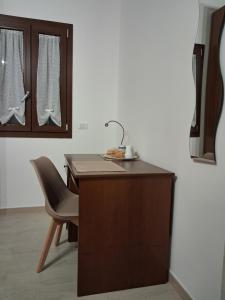 a kitchen with a desk with a sink and a chair at La Rugiada-con giardino privato in Alcamo +45 photos