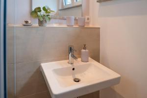 a white sink in a bathroom with a mirror at Stivolles Ambiente in Niendorf! in Hamburg