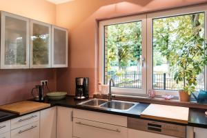 a kitchen with a sink and a window at Stivolles Ambiente in Niendorf! in Hamburg +6 photos