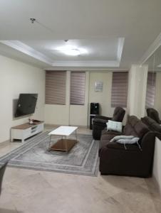 a living room with a couch and a tv at Resa Living in Mantaak +4 photos