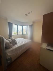 a bedroom with a bed and a large window at Resa Living in Mantaak