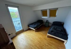 a small room with two beds and a window at Gemütliche 2 Zimmerwohnung mit großer Terrasse in Andernach