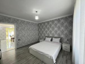 a bedroom with a white bed and a window at AllGreen House in Gabala
