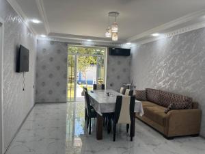 a dining room with a table and a couch at AllGreen House in Gabala