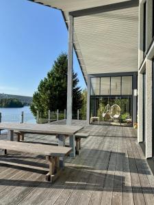 a picnic table on a dock with a view of the water at Aurora Arctic Riverside Villa in Rovaniemi