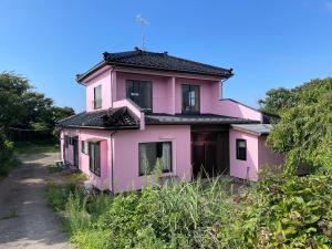 a pink house sitting on the side of a road at Tensen inn on the bay, Toriumi Mountain, Akita, Yamagata sightseeing, detached house rental 
