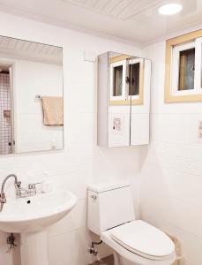 a white bathroom with a toilet and a sink at COZY BUTTERHOUSE, Near Metro, Close to Airport, Hongdae, WIFI, Long Biz Trip, Local Vibe in Seoul