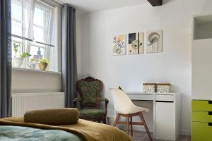 a bedroom with a bed and a desk and a chair at Charmante 120qm Dachgeschoß-Wohnung in Lippstadt