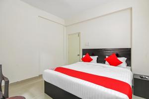 Un dormitorio con una cama grande con almohadas rojas. en Hotel O HILL 9, en Hyderabad 21 fotos más