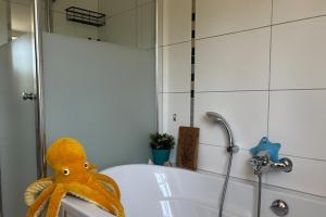 a stuffed animal sitting on the edge of a bath tub at Charmante 120qm Dachgeschoß-Wohnung in Lippstadt +34 photos