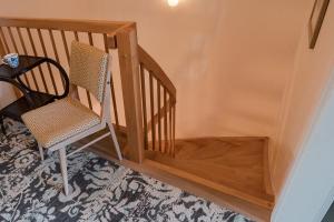 eine Holztreppe mit einem Stuhl und einem Tisch in der Unterkunft Stilvolles Ambiente im grünen Hamburg! in Hamburg