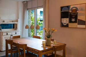 eine Küche und ein Esszimmer mit einem Holztisch und Stühlen in der Unterkunft Stilvolles Ambiente im grünen Hamburg! in Hamburg