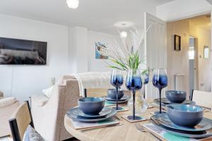 a dining room with a wooden table with blue glasses at Modern 3-Bed 3-Bath Home - Quiet Road - Parking For 2 Cars - LMV Property in Great Burstead