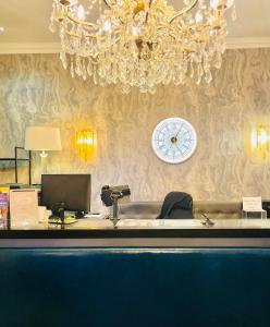 a chandelier and a desk with a clock on a wall at Bloomsbury Palace Hotel in London
