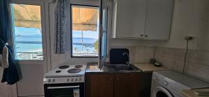 a kitchen with a sink and a stove and a window at Selena Rooms in Agia Galini