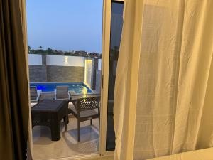 a room with a balcony with a table and chairs at Nefertarie Villa in Luxor +7 photos