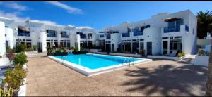 a large building with a swimming pool in front of it at RED in Puerto del Carmen