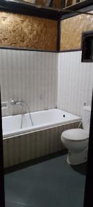 a bathroom with a tub and a toilet and a sink at Villa bungalow restoApung in Kubupenlokan