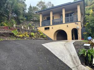 a driveway leading to a house with a balcony at Lismore Hillside Home on Ballina Road in Lismore