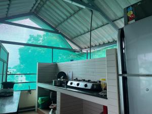 a kitchen with a stove and a large window at Aroma Serviced Villa Cochin in Cochin