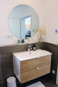 a bathroom with a sink and a mirror at Seeliebe Ferienwohnung am Brombachsee in Pleinfeld