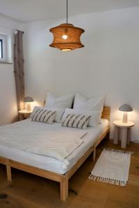 a bed in a room with a chandelier at Seeliebe Ferienwohnung am Brombachsee in Pleinfeld