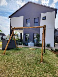 a swing set in front of a house at Urban Contempo Lush in Fourways