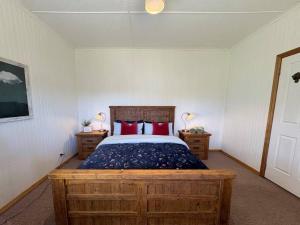 a bedroom with a bed with red pillows on it at Briar Cottage Weldborough in Weldborough