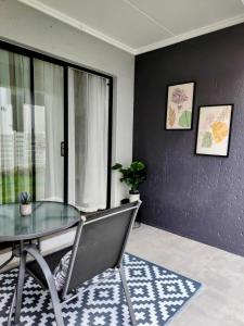 a dining room with a glass table and chairs at Urban Contempo Lush in Fourways