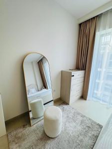 a bedroom with a mirror and a chair and a stool at Apartment In Creek Beach in Dubai