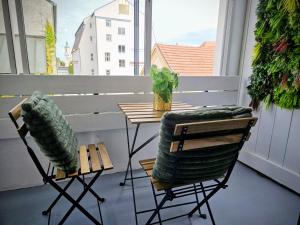 a balcony with two chairs and a table on a porch at Chic 2-room apartment in the historic cathedral district in Augsburg