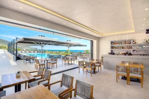 ein Restaurant mit Tischen und Stühlen und Meerblick in der Unterkunft Toska Tower in Chrisi Ammoudia