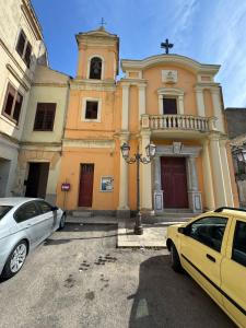 a church with two cars parked in front of it at Stanze Matrimoniali Nicchia della Ninfa in Castelvetrano Selinunte