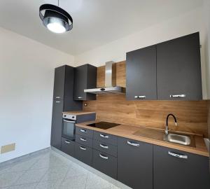 a kitchen with gray cabinets and a sink at Stanze Matrimoniali Nicchia della Ninfa in Castelvetrano Selinunte +9 photos