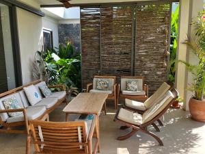 a patio with chairs and a table and a table and chairs at Belle Villa de Grand Baie in Midlands Station