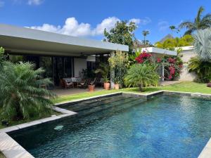 a swimming pool in front of a house at Chambre dans Belle Villa de Grand Baie in Midlands Station