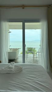 a bedroom with a bed and a tub and a view of the ocean at Sea for Rest beach club  +22 photos