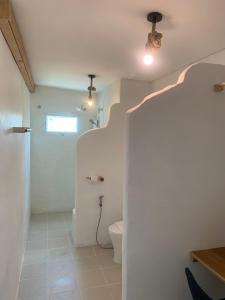 a bathroom with a toilet and a hallway with a ceiling at Sea for Rest beach club 