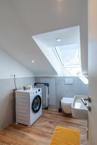 een badkamer met een wasmachine en een wastafel bij Nagoldblick 4 OG in Pforzheim