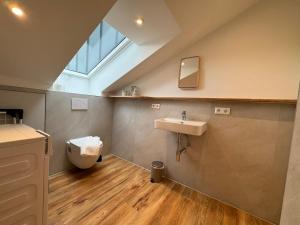 een badkamer met een wastafel en een toilet en een raam bij Nagoldblick 4 OG in Pforzheim +34 foto's