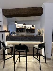 a kitchen with a bar with two chairs and a table at Albergo Pineta dal 1891 in Villetta Barrea +19 photos