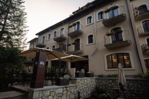 a building with an umbrella in front of it at Albergo Pineta dal 1891 in Villetta Barrea