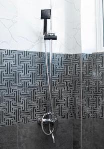 a shower in a bathroom with a labyrinth pattern on the wall at Danish Crown Hotel in Ambalangoda +53 photos