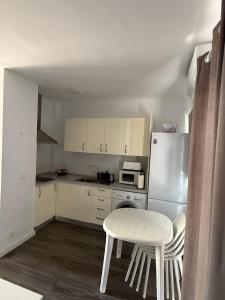 a small kitchen with a table and a refrigerator at Solarena - Sol44 in Maspalomas
