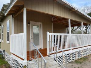 a small house with a porch and a white railing at Country Home close to Town in Harlingen