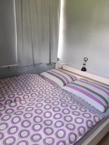 a bed with two pillows sitting next to a window at Apartmán Na Kvildě in Kvilda