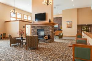 a lobby with a fireplace and a tv on top at White River Inn & Suites in White River Junction